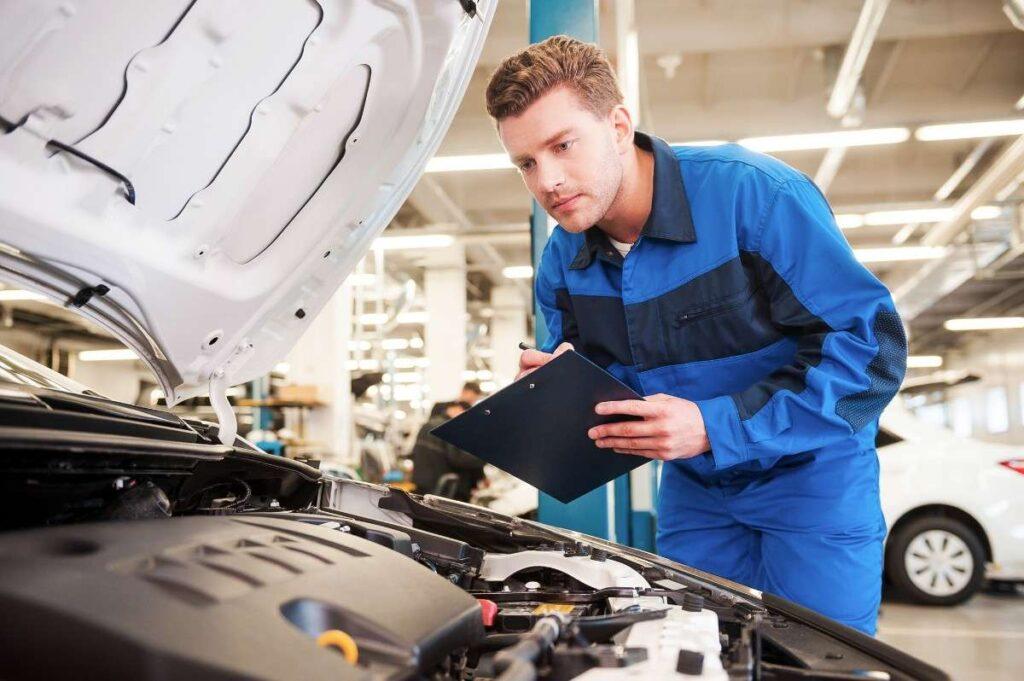Auto technician inspecting an engine and fuel system issue during vehicle diagnostic in Portland, OR
